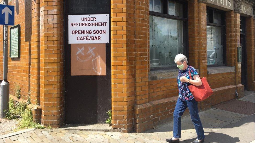 woman walking past disused pub in Pontypool