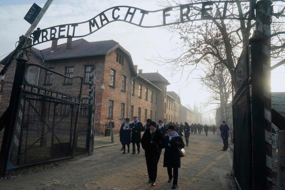 Holocaust survivors walk through the grounds of former German Nazi death camp Auschwitz