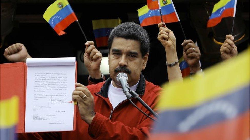 Venezuela's President Nicolas Maduro shows a document with the details of a constituent assembly to reform the constitution during a rally at Miraflores Palace in Caracas, Venezuela May 23, 2017.