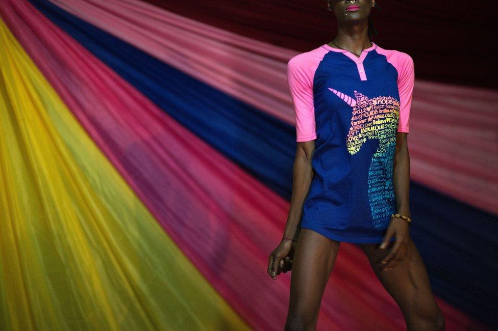 Person standing in front of a rainbow backdrop