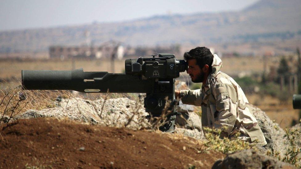 An opposition fighter looks for government forces' positions in Syria's south-western Quneitra province on June 28, 2017