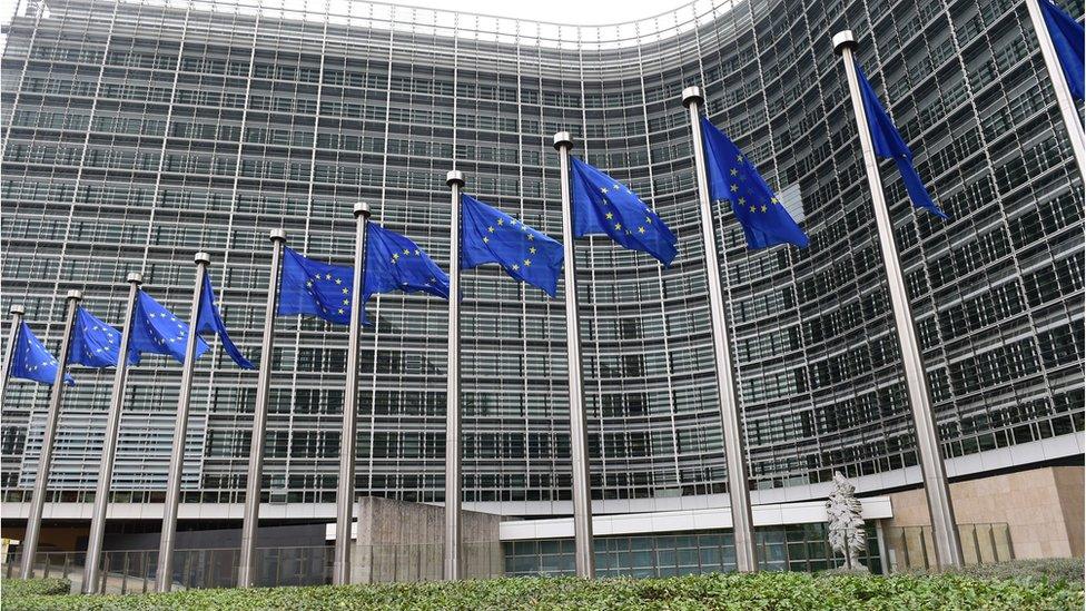 European Commission headquarters, HQ / Berlaymont building, with European Union flags, Brussels.