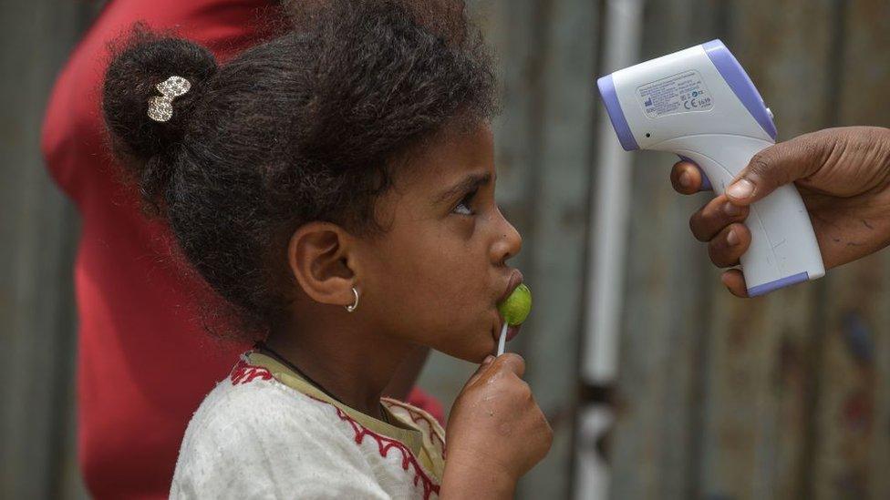 Health Extension workers of the Ministry of Health measure the tempreature of a girl during a door to door screening to curb the spread of the COVID-19 coronavirus in Addis Ababa, Ethiopia, on April 20, 2020