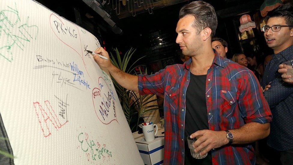 Guests sign a Casper mattress during Casper's LA celebration at Blind Dragon on July 9, 2015