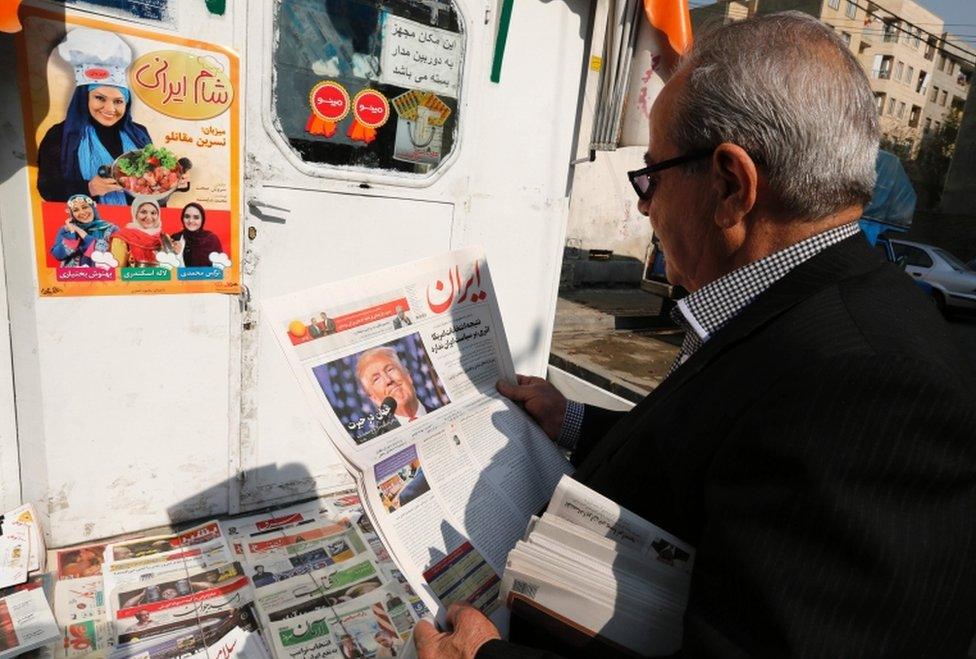 An Iranian man holds a local newspaper with a portrait of Donald Trump a day after his election as the new US president, in the capital Tehran, on November 10, 2016.