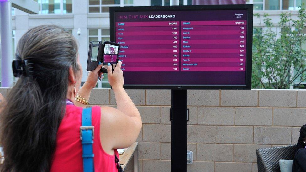 Woman using Blippar software to analyse a displayboard