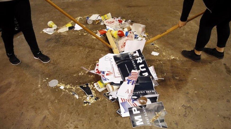 Trash is scooped up, including torn campaign signs for Republican presidential candidate Donald Trump