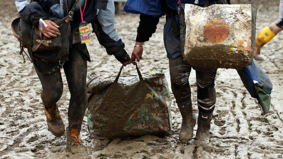 People dragging bag through the mud