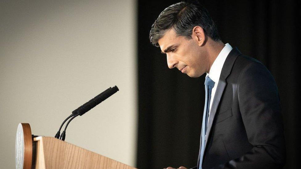 Rishi Sunak looking sadly at a lectern