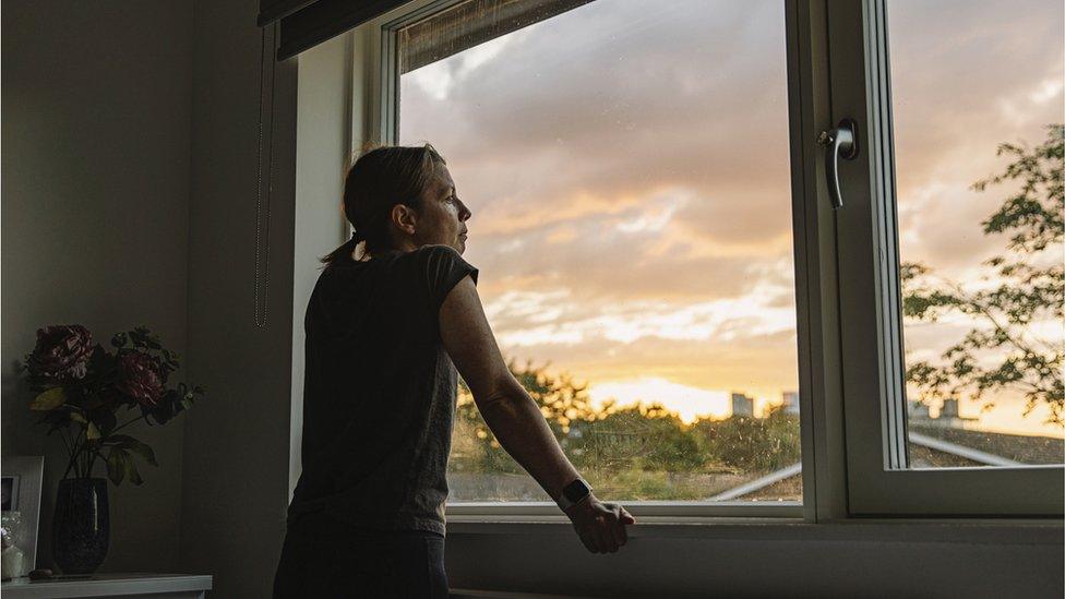 Woman looking outside of window