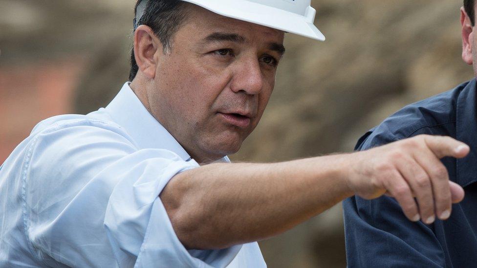 Rio de Janeiro's Governor Sergio Cabral smiles as he visits the site of the construction of a new tunnel to the Transolimpica expressway in Rio de Janeiro, Brazil, on November 08, 2013.