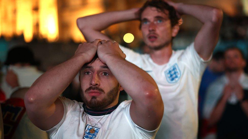 England fans react after Italy won the Euro 2020 at Trafalgar Square