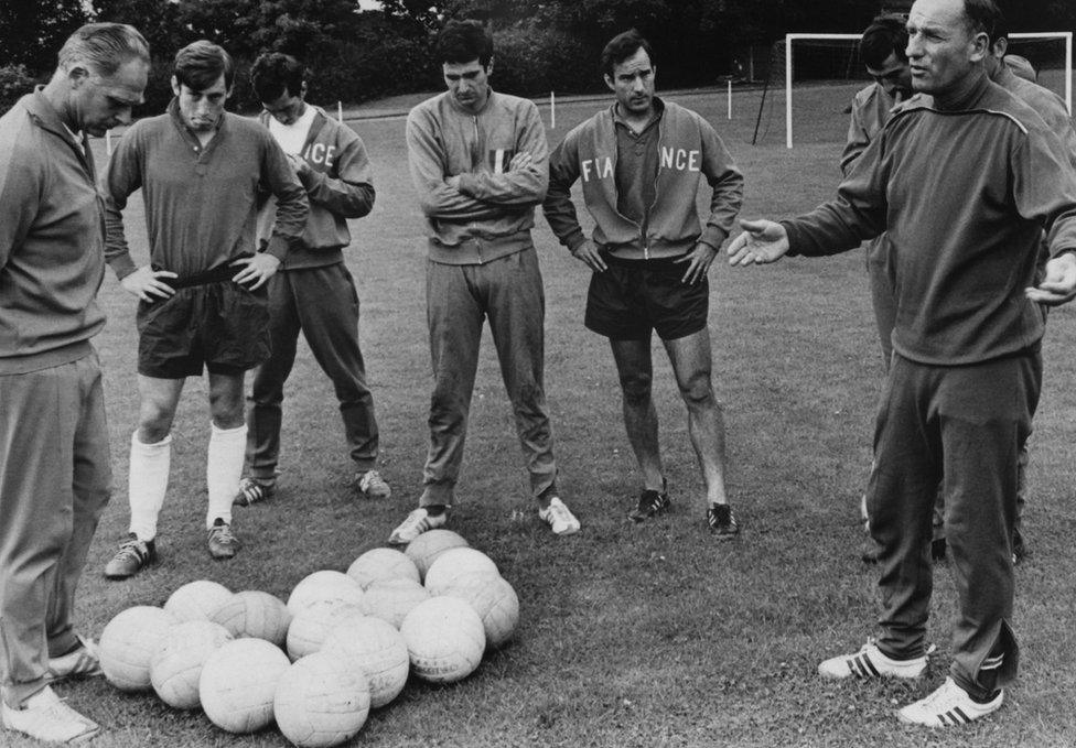 French coach Henri Guerin (right) speaks to the France national team players during a training session on 12 July 12 1966, during the football World Cup in England.