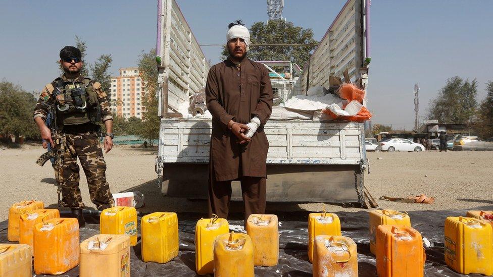 The suspect is paraded in front of the truck bomb in Kabul, 15 October