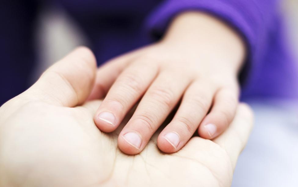 Child and adult holding hands