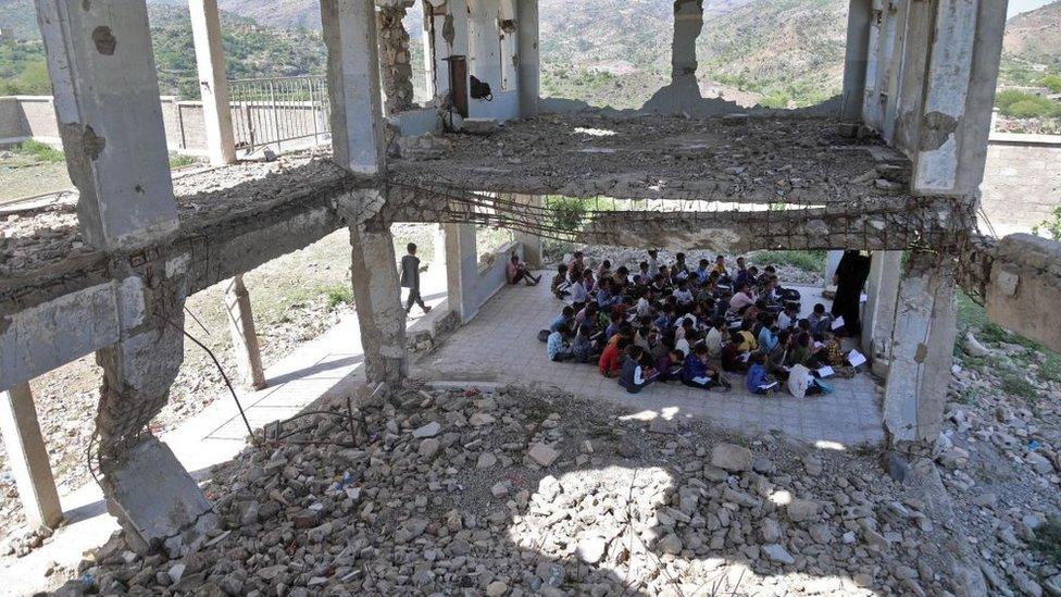 Yemeni pupils attend class on the first day of the new academic year, in a makeshift classroom in their school compound which was heavily damaged in the fighting between the government and Iran-backed Huthi rebels, in the country's third-city of Taez on October 7, 2020.