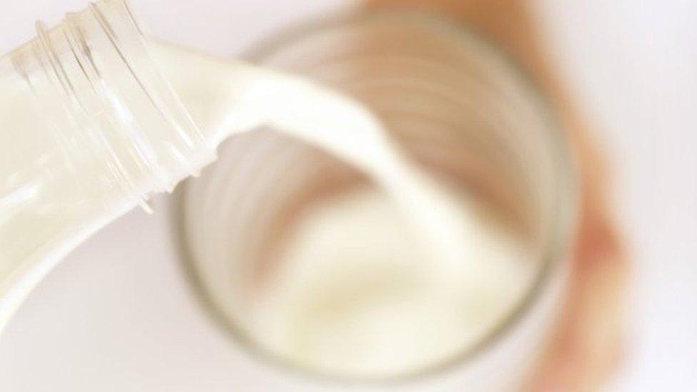 Milk being poured from a bottle into a glass