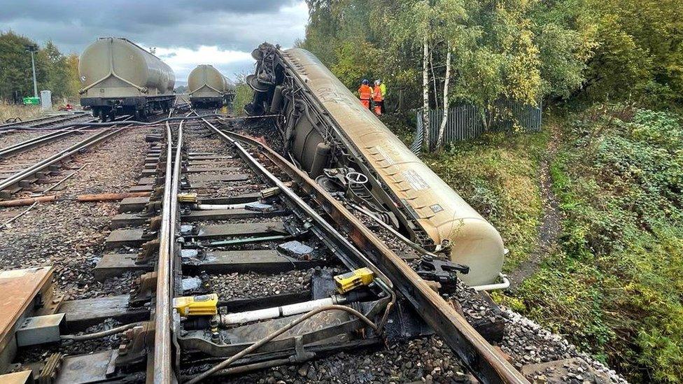 A wagon on its side off the tracks