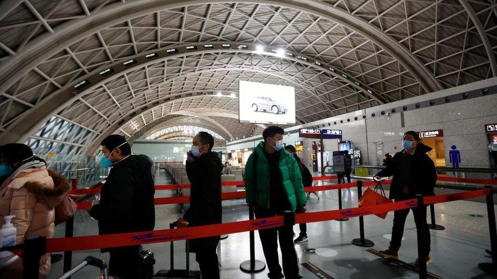 Travellers queue to board a plane at Chengdu Shuangliu International Airport