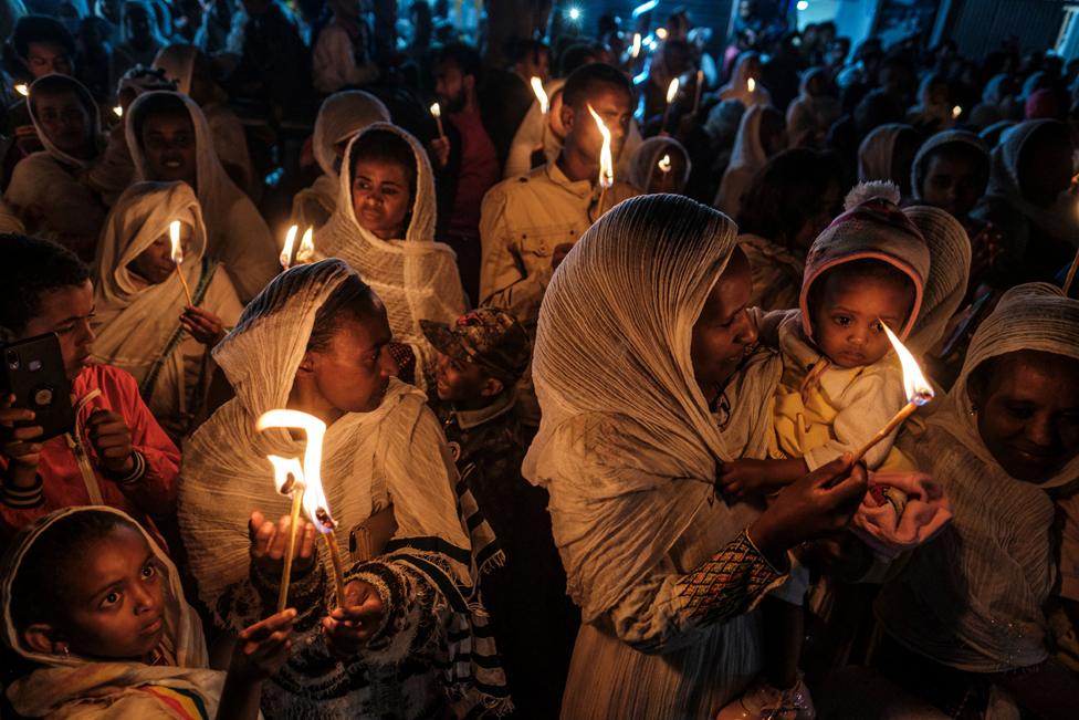 Orthodox devotees hold candles during the celebrations on the eve of the Ethiopian Orthodox holiday of Meskel in Addis Ababa on 26 September 2022.