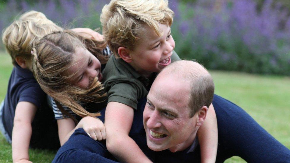 The Duke of Cambridge plays on the grass with (R-L) Prince George, Princess Charlotte and Prince Louis