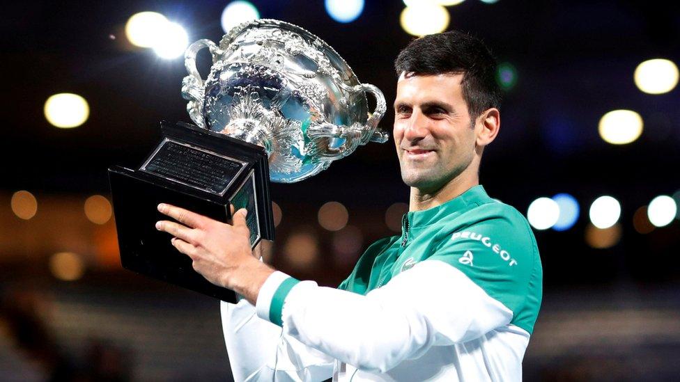 Serbia"s Novak Djokovic celebrates with the trophy after winning his final match against Russia"s Daniil Medvedev at Australian Open