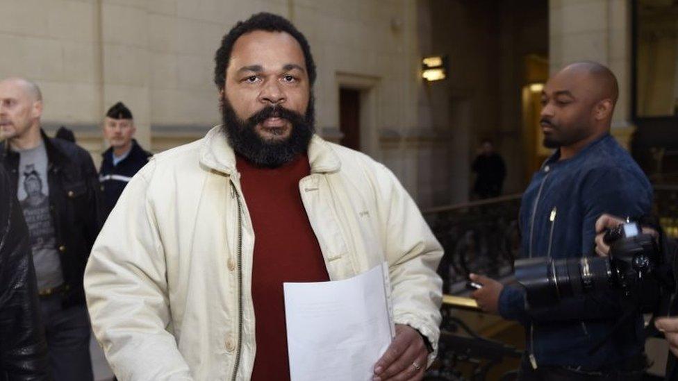 French comic Dieudonne M'bala M'bala (centre ) arriving at the Paris courthouse (12 March 2015)