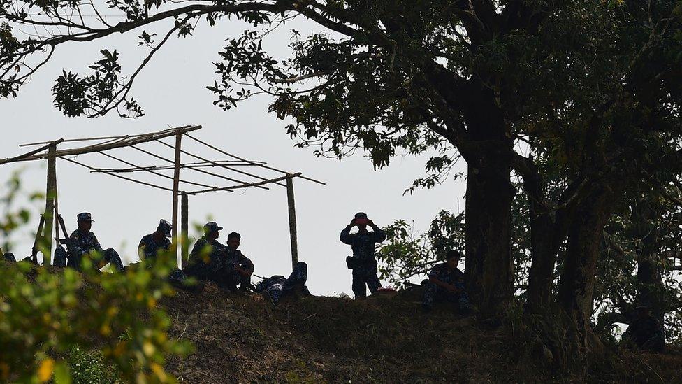 Myanmar security forces keep watch over the camp