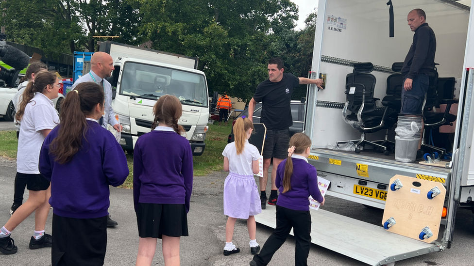 Pupils watching furniture being unloaded