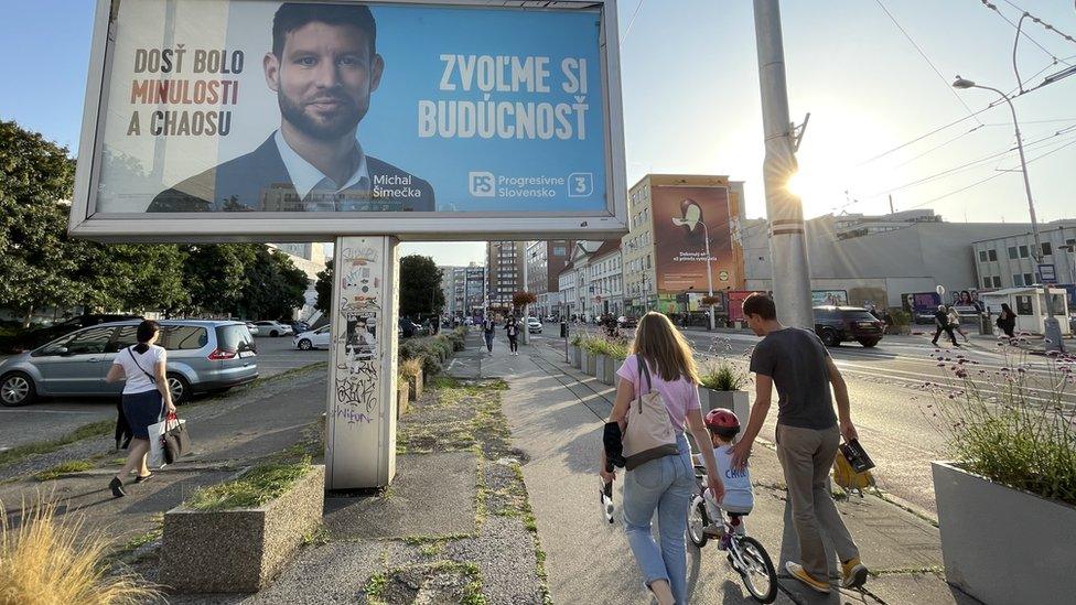 Billboard caption reads 'Enough of the past and chaos. Let's choose the future'