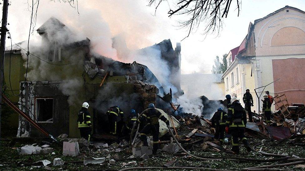 Firefighters work at a site of a residential building damaged by a Russian military strike