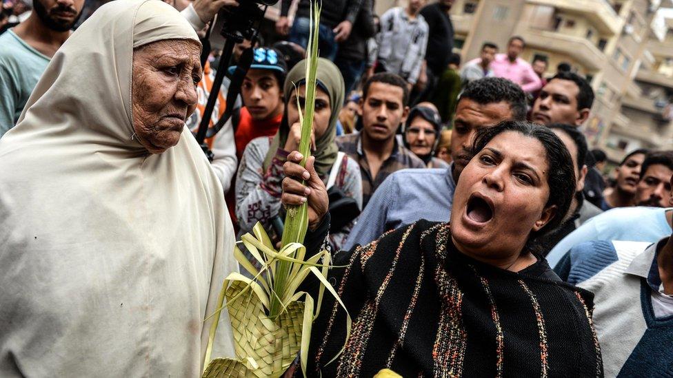 People gather in front of Mar Girgis church after a bomb explosion in Tanta