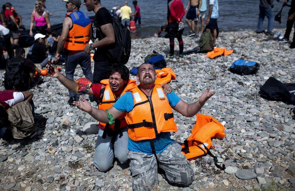 Refugees from Syria pray after arriving on the shores of the Greek island of Lesbos