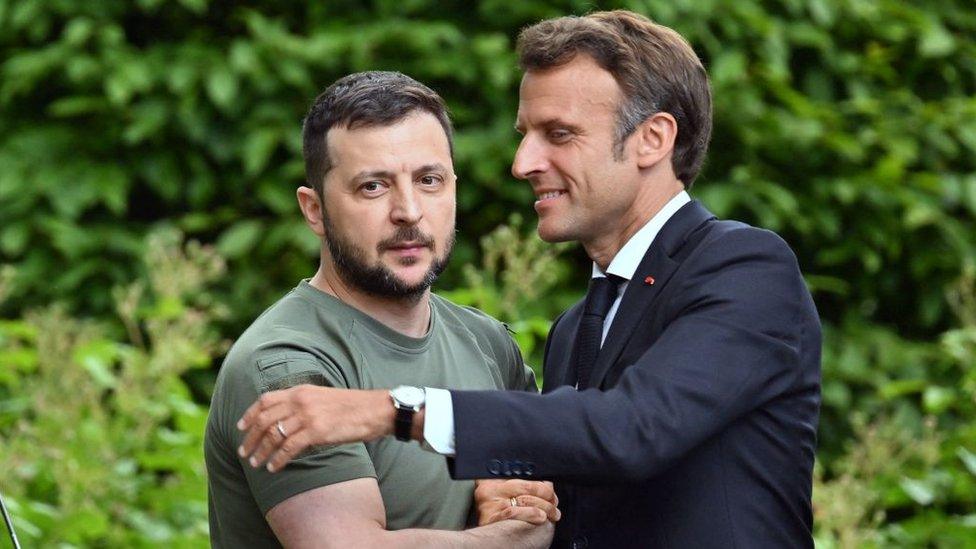 Ukrainian President Volodymyr Zelensky (L) and French President Emmanuel Macron shake hands after giving a press conference in Kyiv, on June 16, 2022