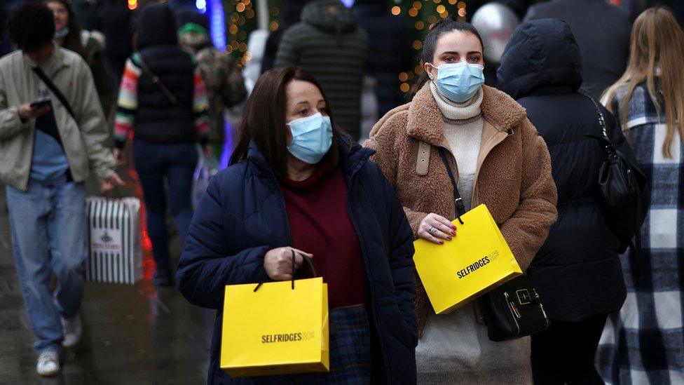 Shoppers walk past Selfridge's flagship store on London's Oxford Street.