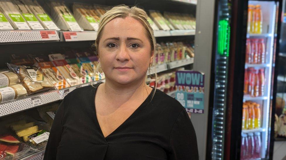 Woman standing in front of shelves of food