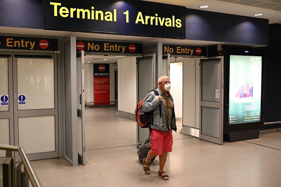 Passenger arriving in airport wearing mask