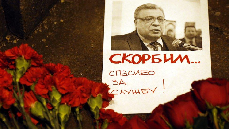 Flowers lie near a picture of Russia's ambassador to Turkey Andrei Karlov outside the Russian foreign ministry in Moscow