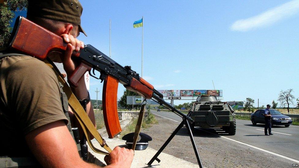 A Ukrainian serviceman guards the road at the border of the western city of Uzhhorod