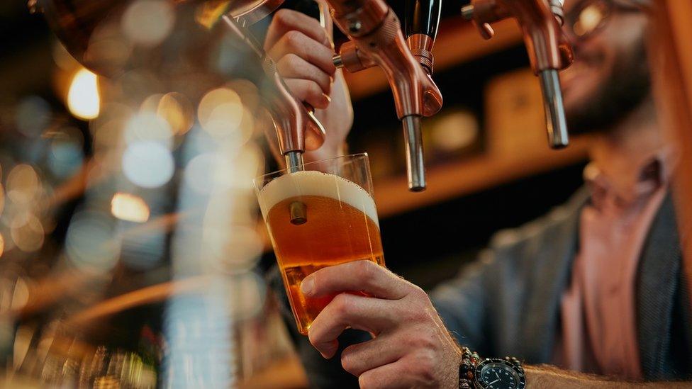 Barman pouring pint in pub