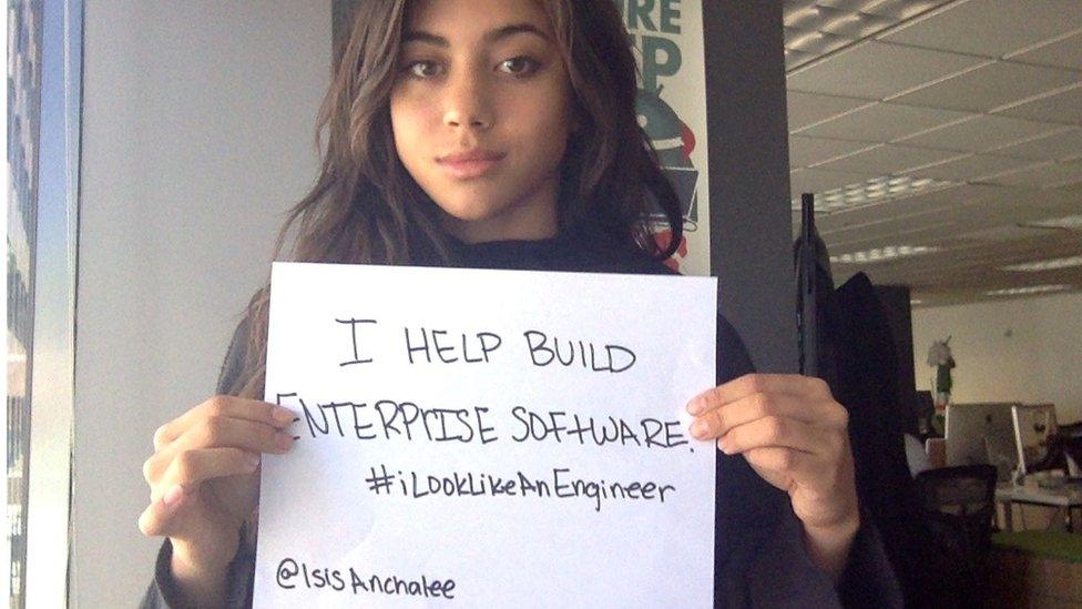 Isis Anchalee holding up a sign which says "I look like an engineer"