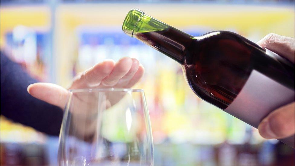 Person pouring wine into glass