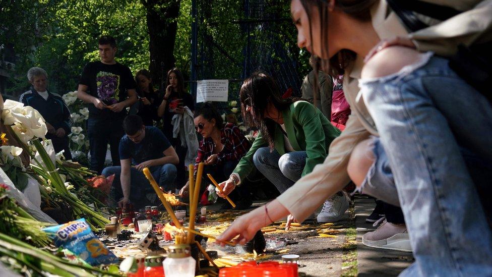 People lay flowers outside the Vladislav Ribnikar elementary school in Belgrade