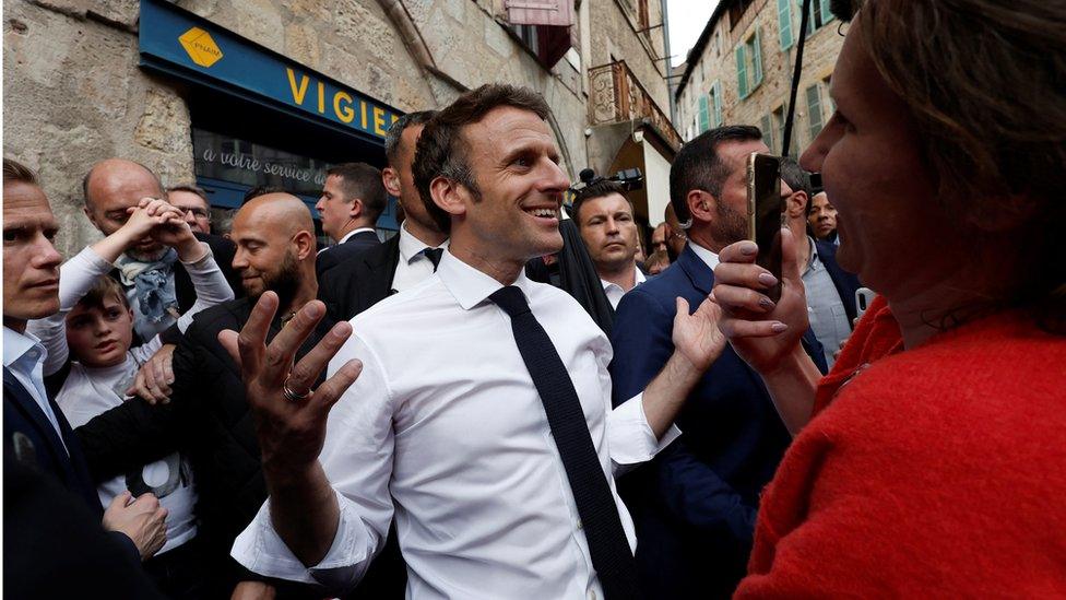 French President Emmanuel Macron, candidate for his re-election in the 2022 French presidential election, reacts as he meets with supporters after a campaign rally in Figeac