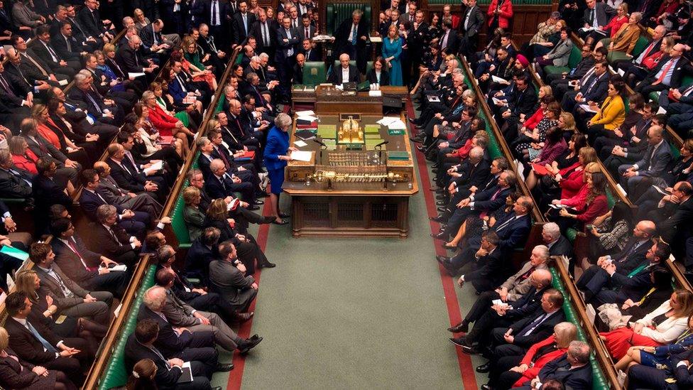 A handout photograph released by the UK Parliament shows Britain's Prime Minister Theresa May (centre left) as she speaks in the House of Commons