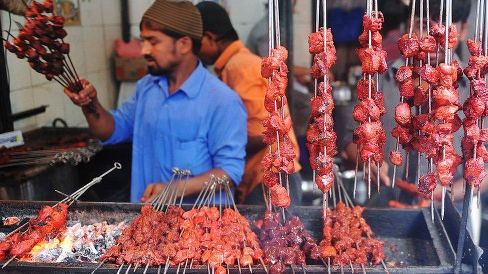 An Indian Muslim vendor grills meat kebabs over burning coals at a roadside stall in preparation for Muslims breaking their fast at sundown in Mumbai on August 19, 2010.