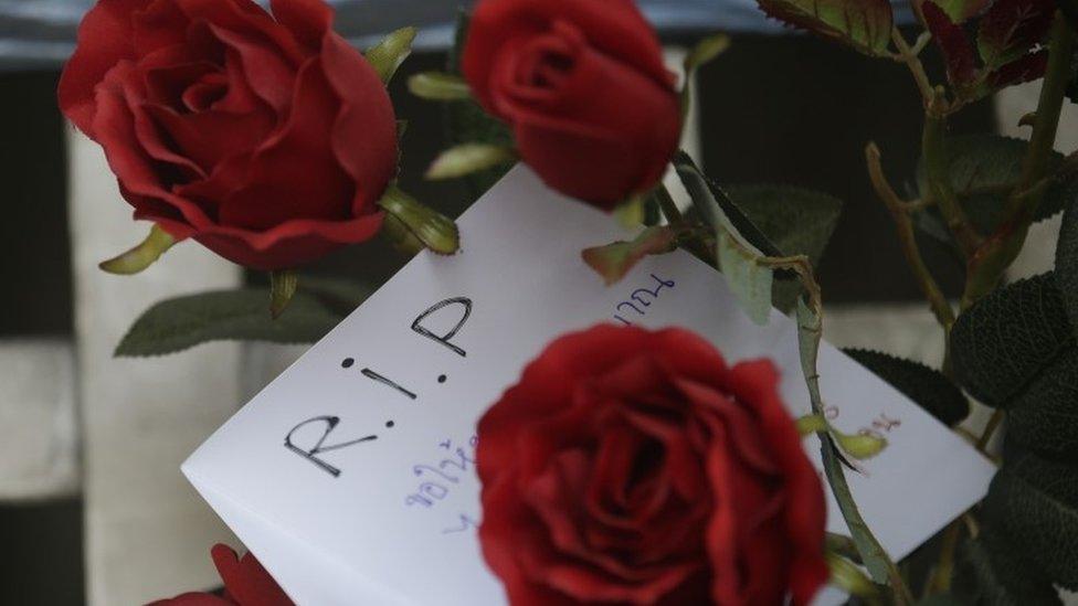 A message of condolence and roses are left for victims of the bomb blast at Rajprasong intersection near the Erawan Shrine in Bangkok, Thailand, Tuesday, Aug. 18, 2015.