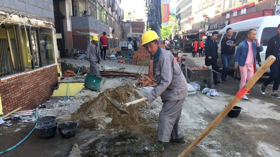 Beijing workers knocking down small shops