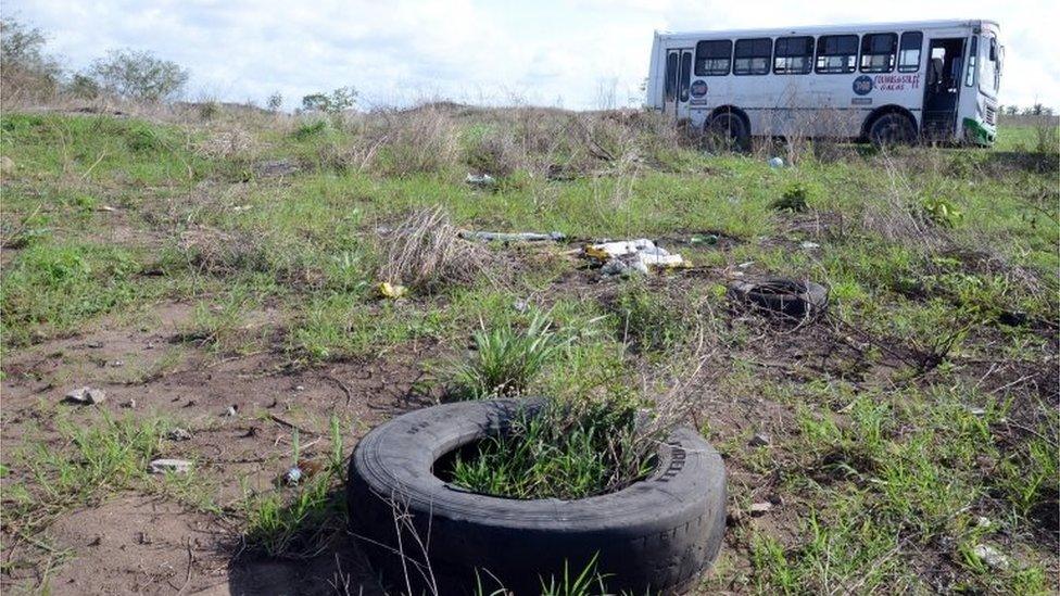 A general view shows a bus (back) at a field as members of the General Prosecutor's Office of the State of Veracruz (unseen) prevented access to the Colinas de Santa Fe in Veracruz, Mexico, 14 March 2017