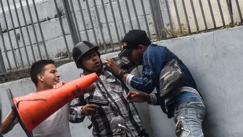 A man wields a gun outside the National Assembly building